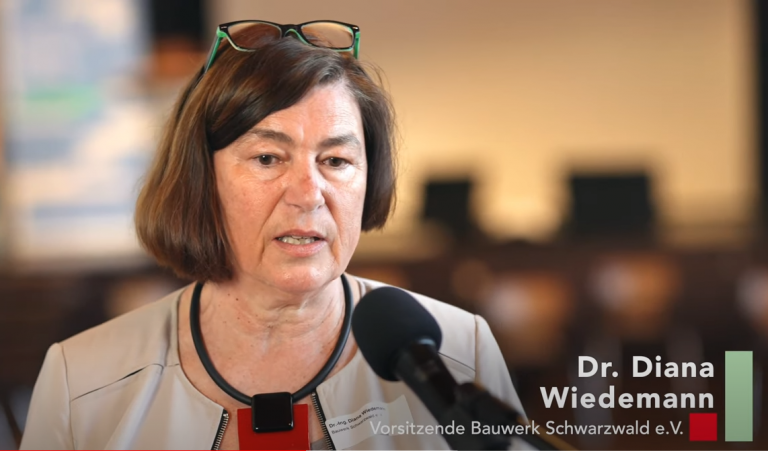 Das Bild zeigt einen Moment aus dem Baukultur-Dialog 2022, bei dem Architekten, Handwerker und Entscheider über die Zukunft der Baukultur diskutieren. Der Fokus liegt auf dem Austausch zwischen Experten und der Bedeutung von Holzbau und Handwerk für eine neue Umbaukultur. - Diskussion beim Baukultur-Dialog 2022 zu Holzbau und Handwerk in Arnsberg. ​