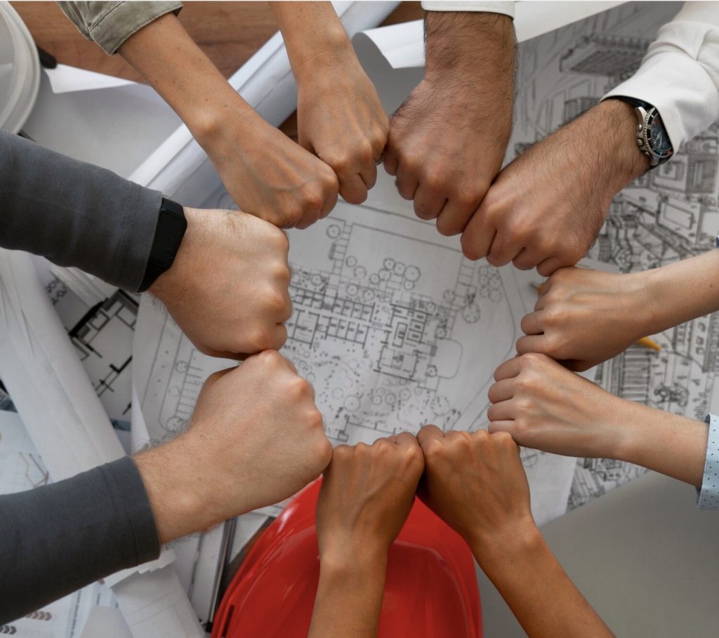 Grundmann Wiedemann Architekten Innenarchitekten Eine Haender Machen einenFaustkreis mit Architektur Plan darunter